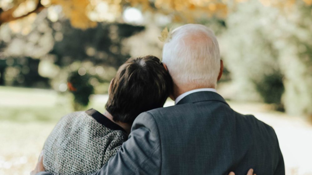 Older couple learning on each other