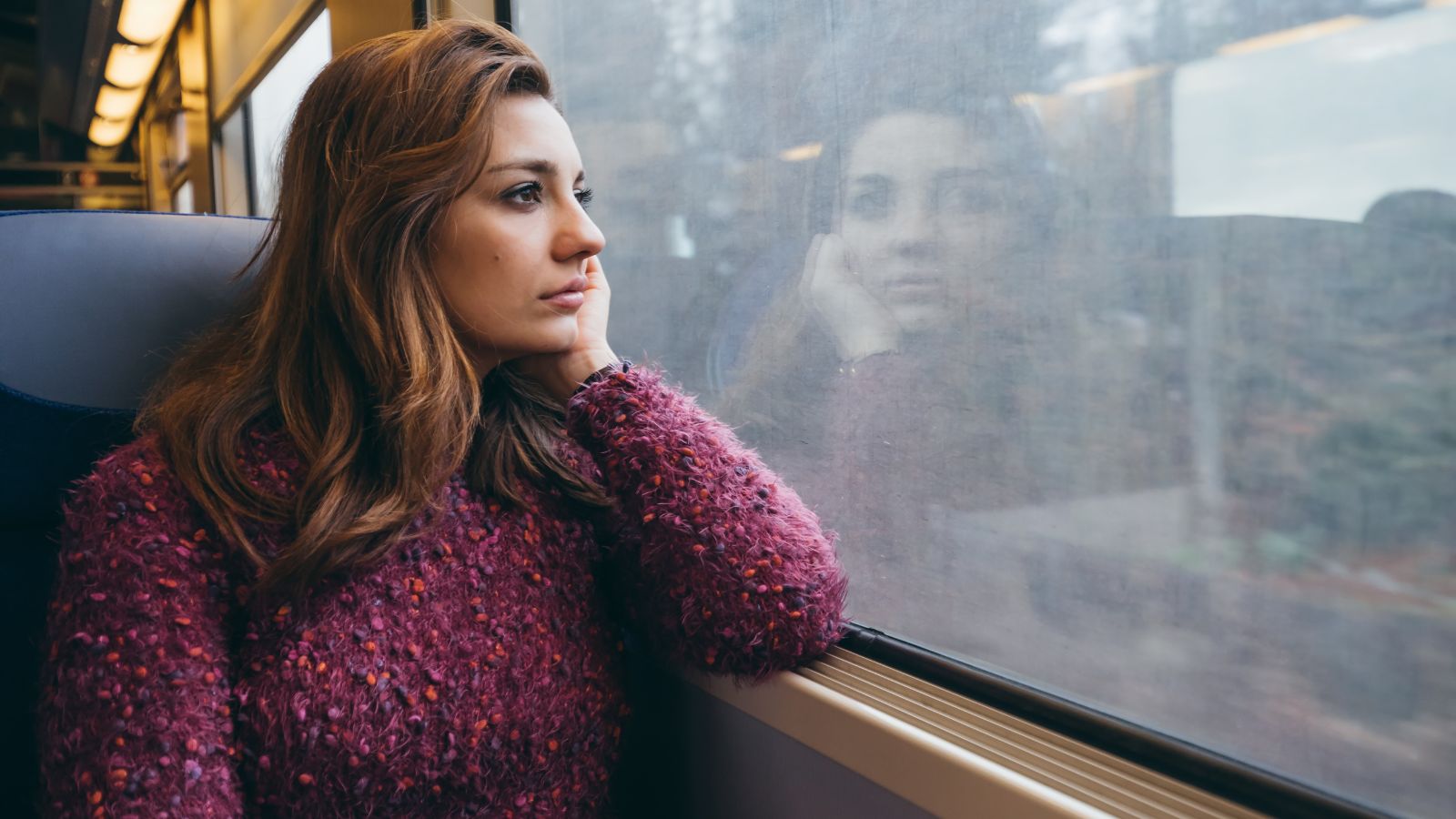 Woman on a train looking out the window