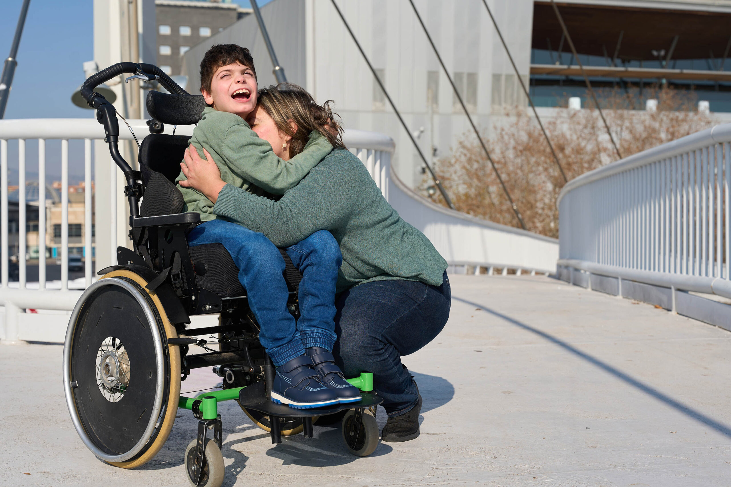 Boy,With,Disability,In,Wheelchair,Hugging,His,Mother,On,A Boy with disability in wheelchair hugging his mother